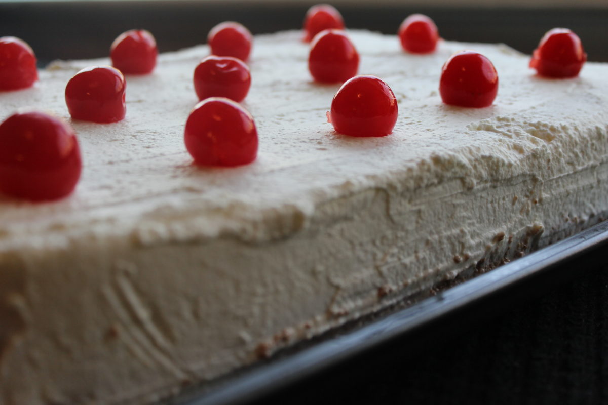 This Tres Leches Cake is soaked in three different kinds of milk and topped with freshly made cream and a cherry.
